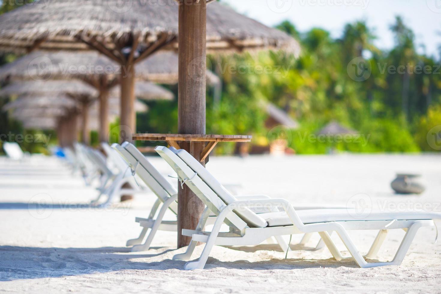 Beach wooden chairs for vacations on tropical beach photo