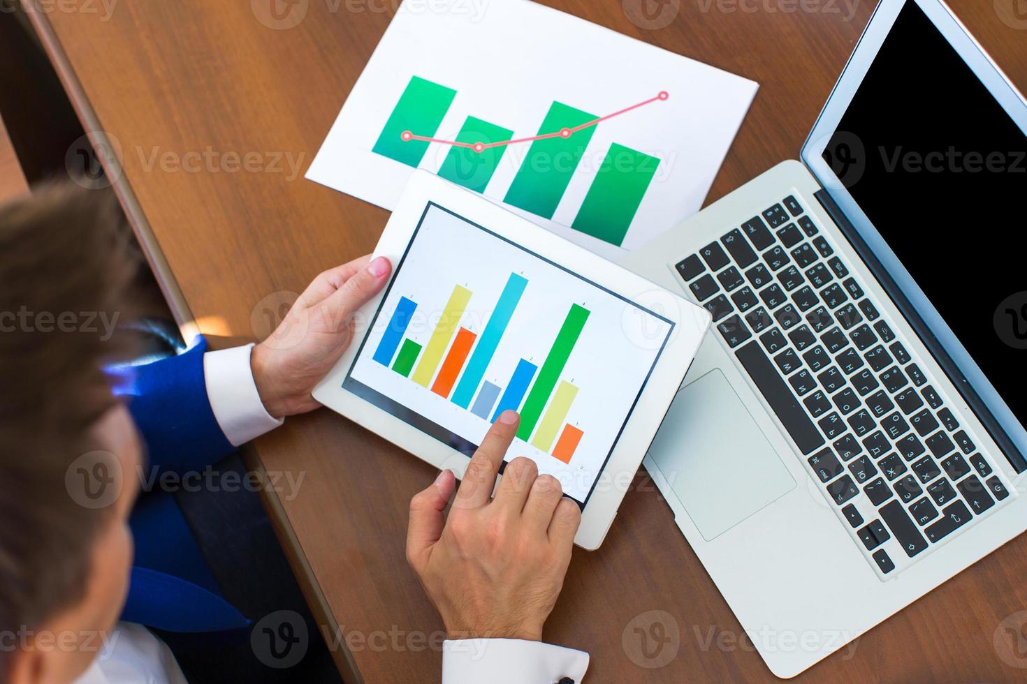 Young businessman working with modern devices, digital tablet computer and cellphone photo