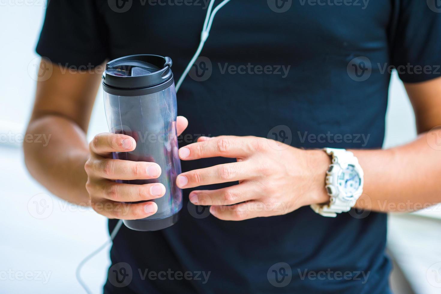 Close-up smart watch heart rate monitor and bottle of water in male hands photo
