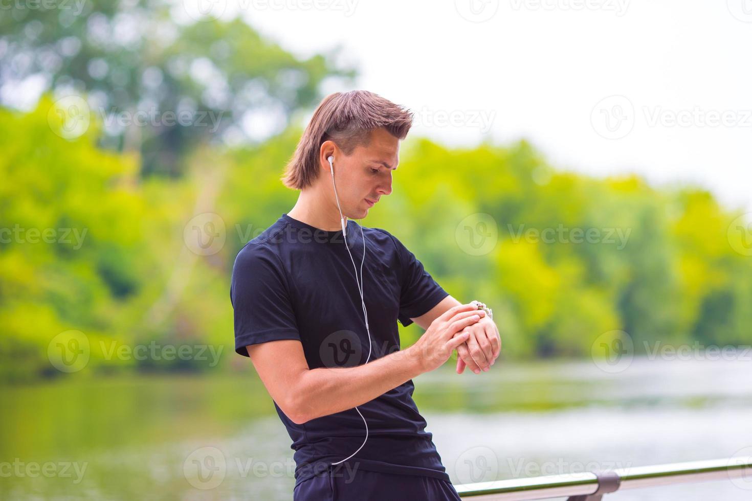 Runner looking at smart watch heart rate monitor having break while running photo