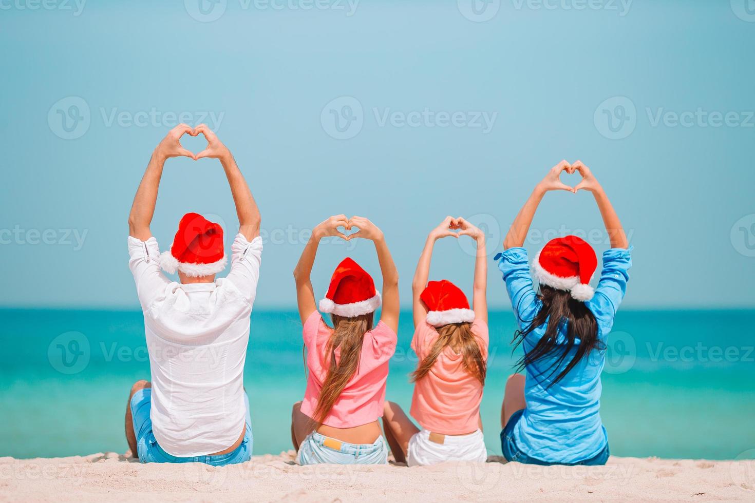 familia feliz con dos niños con sombrero de santa en vacaciones de verano foto