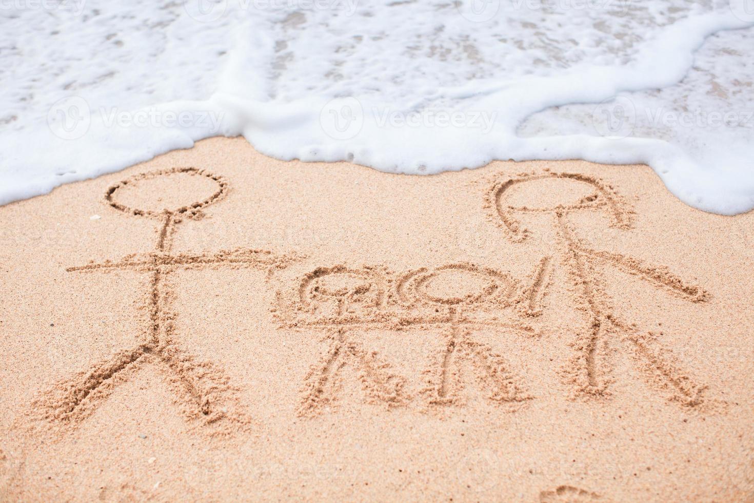 Family of four drawing on the beach photo