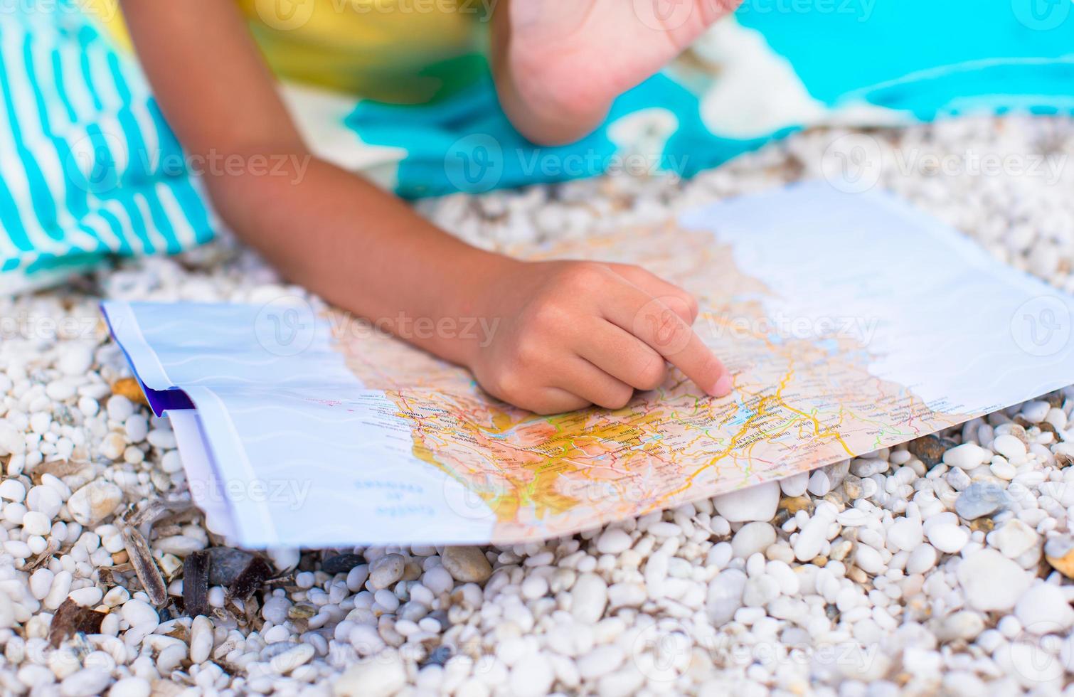 Adorable little girl with map of island on tropical beach photo