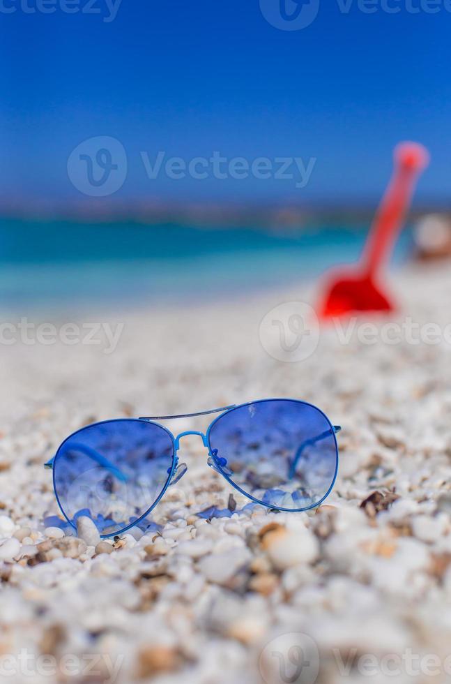 Close up of colorful blue sunglasses on tropical beach photo