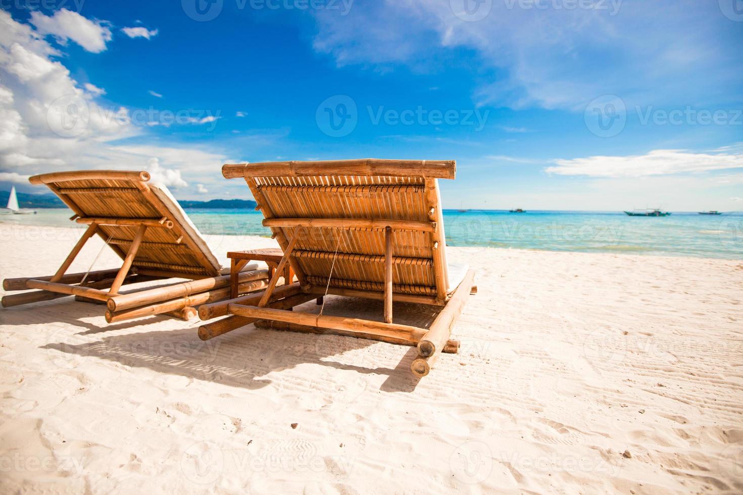 Paradise view of nice tropical empty sandy plage with umbrella and beach chair photo