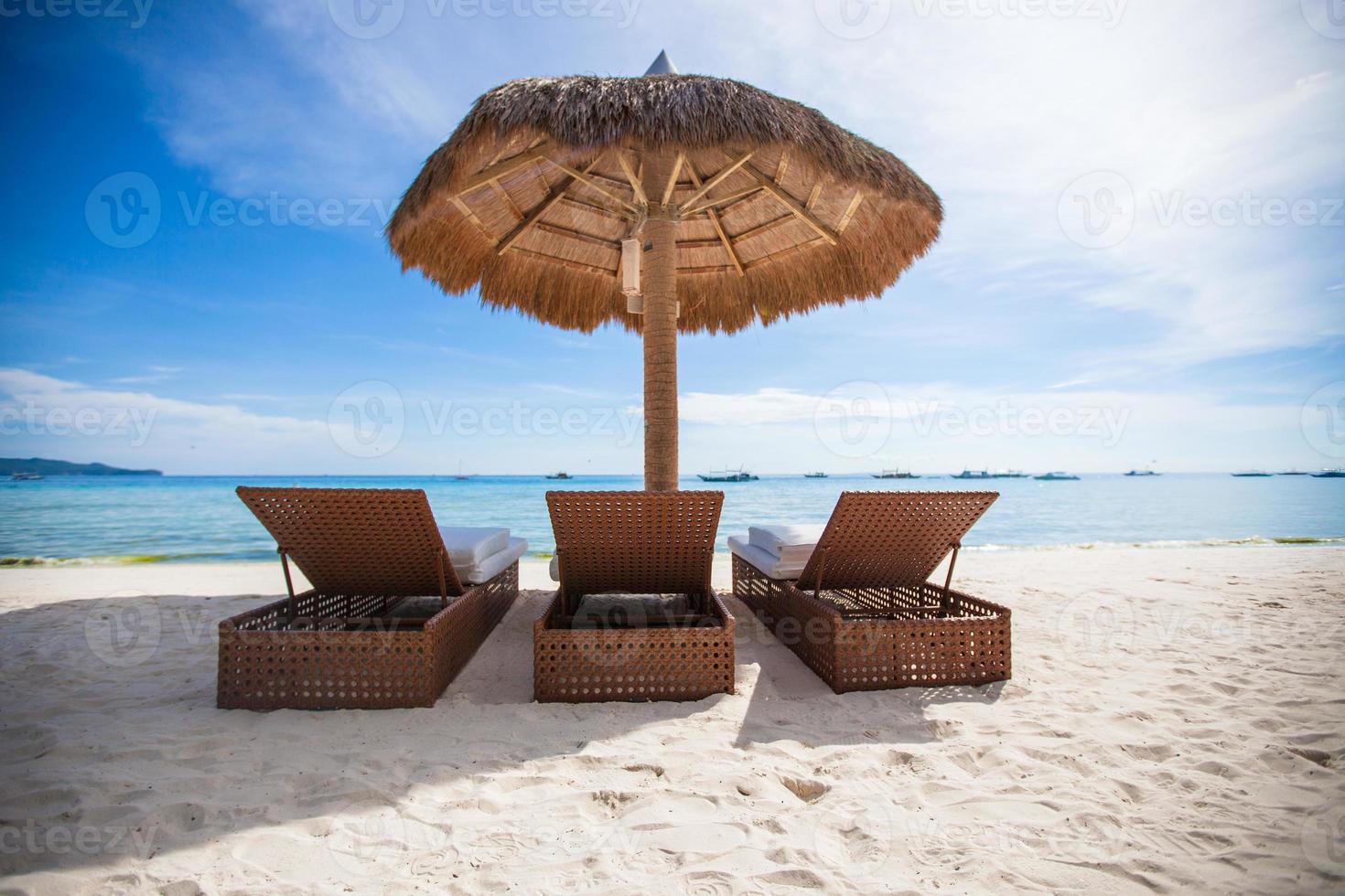 Paradise view of nice tropical empty sandy plage with umbrella and beach chair photo