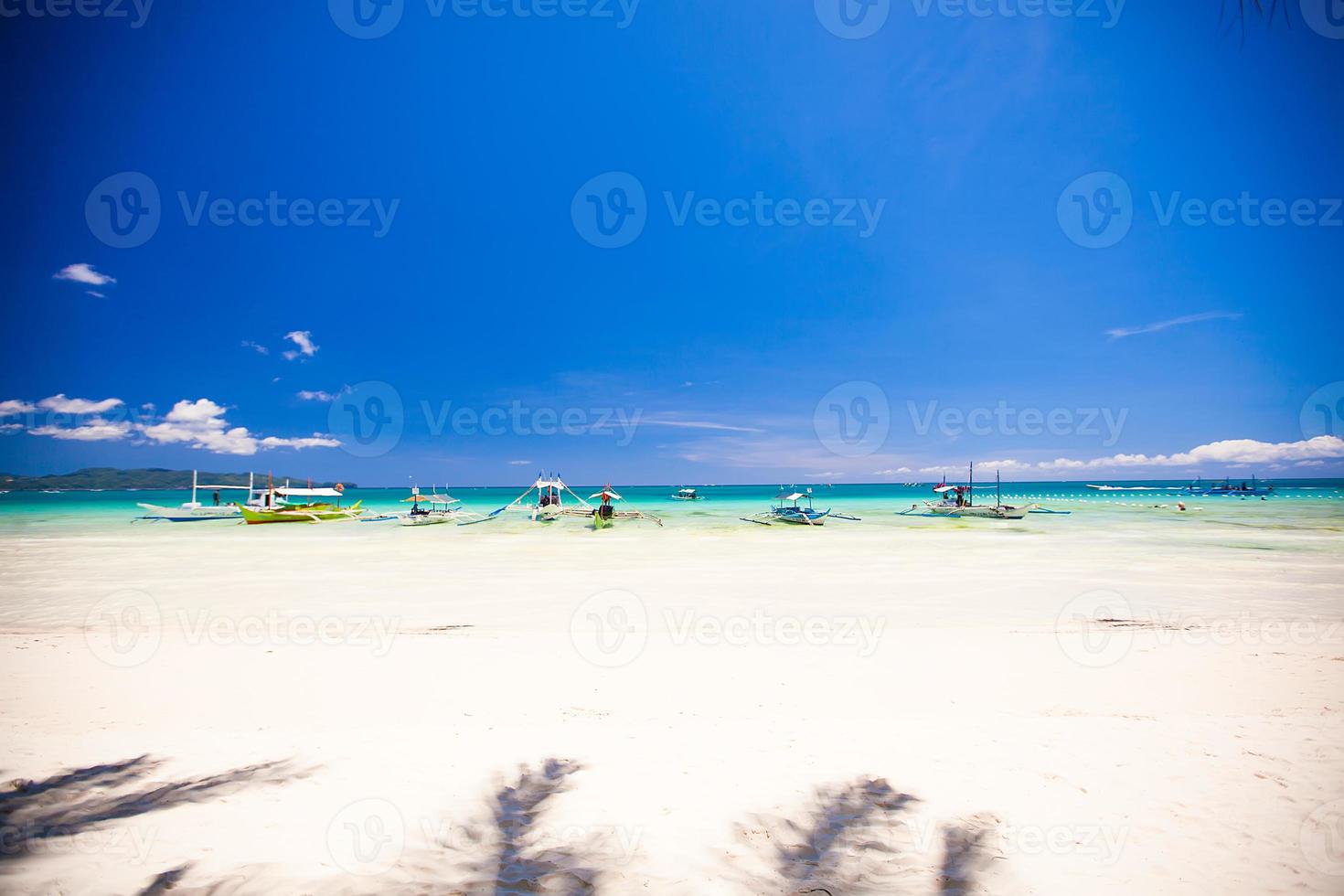 Perfect tropical beach with turquoise water, white sand and sailboats photo