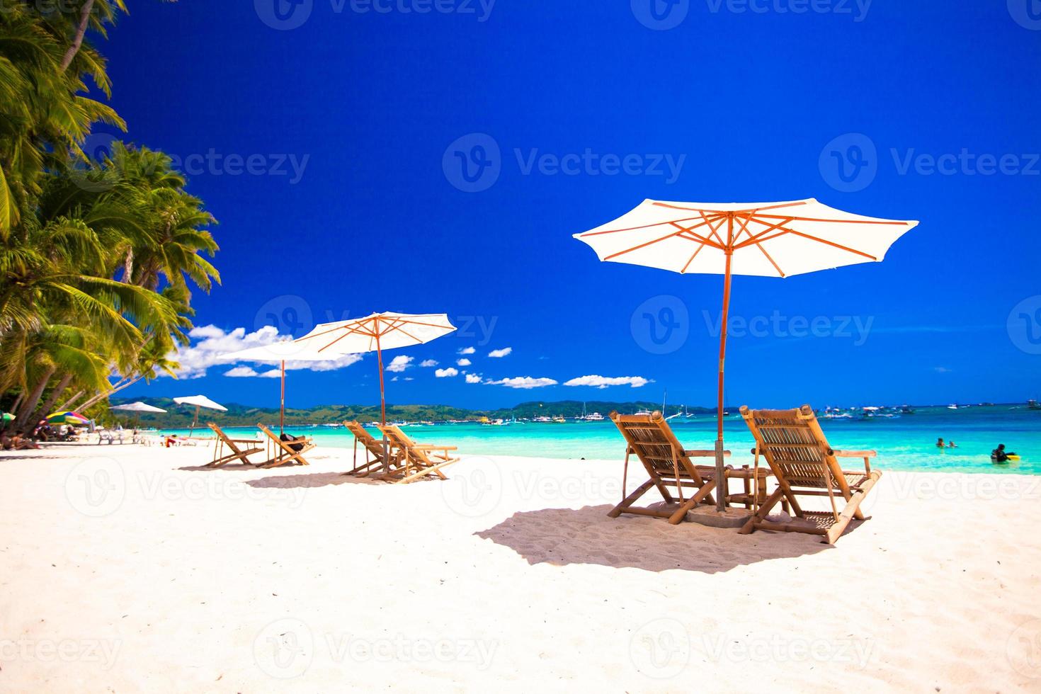 Paradise view of nice tropical empty sandy plage with umbrella and beach chair photo
