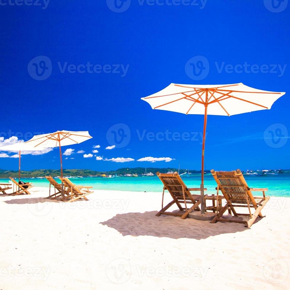 Beach chairs on exotic tropical white sandy beach photo