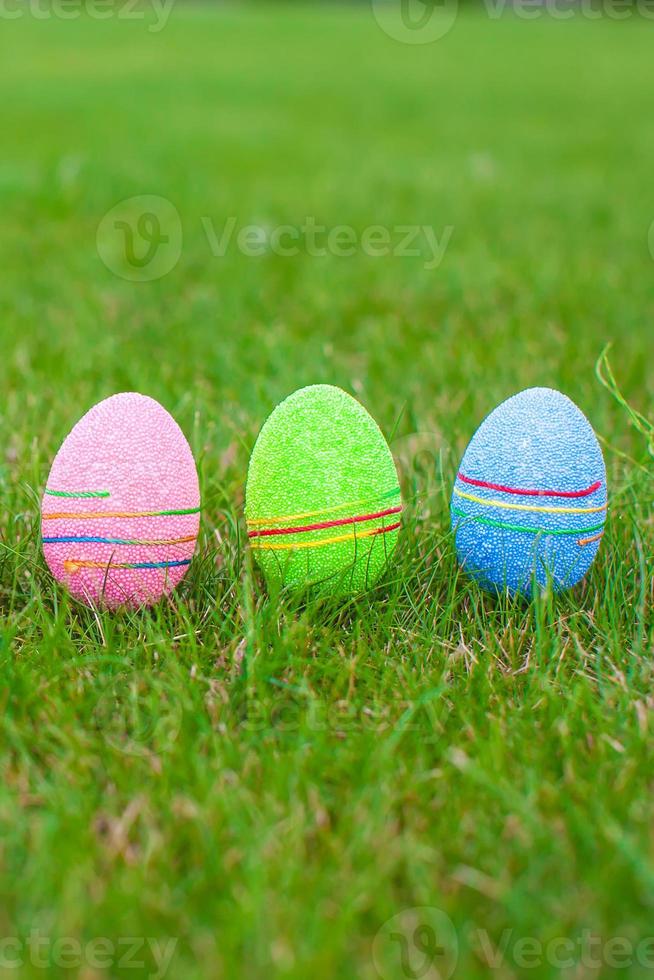 Multi-colored Easter eggs on green grass photo