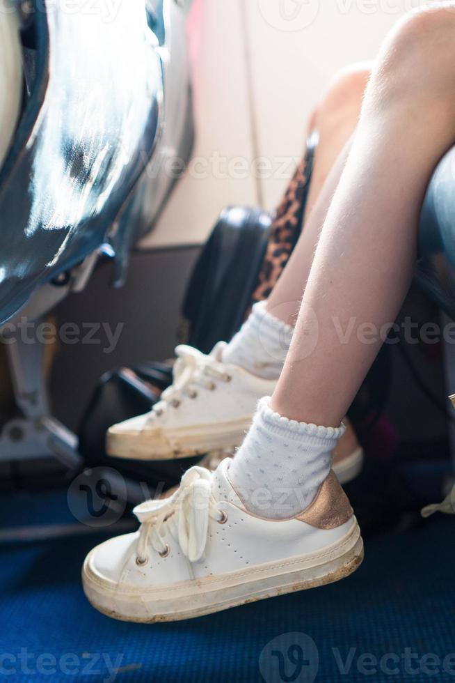 Closeup of baby feet on seat in the aircraft photo