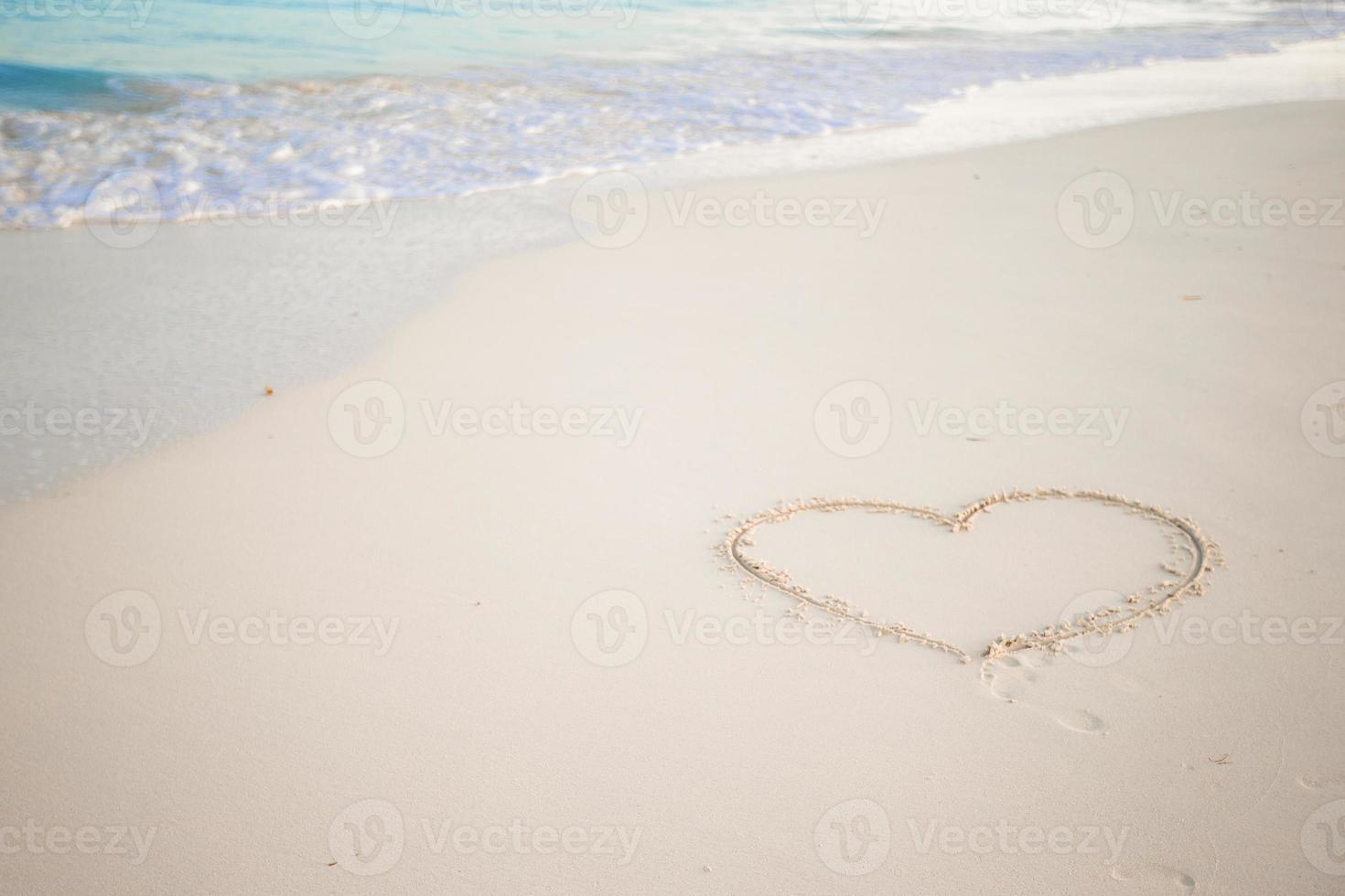 Heart drawn in the sand. Beach background. Top view photo