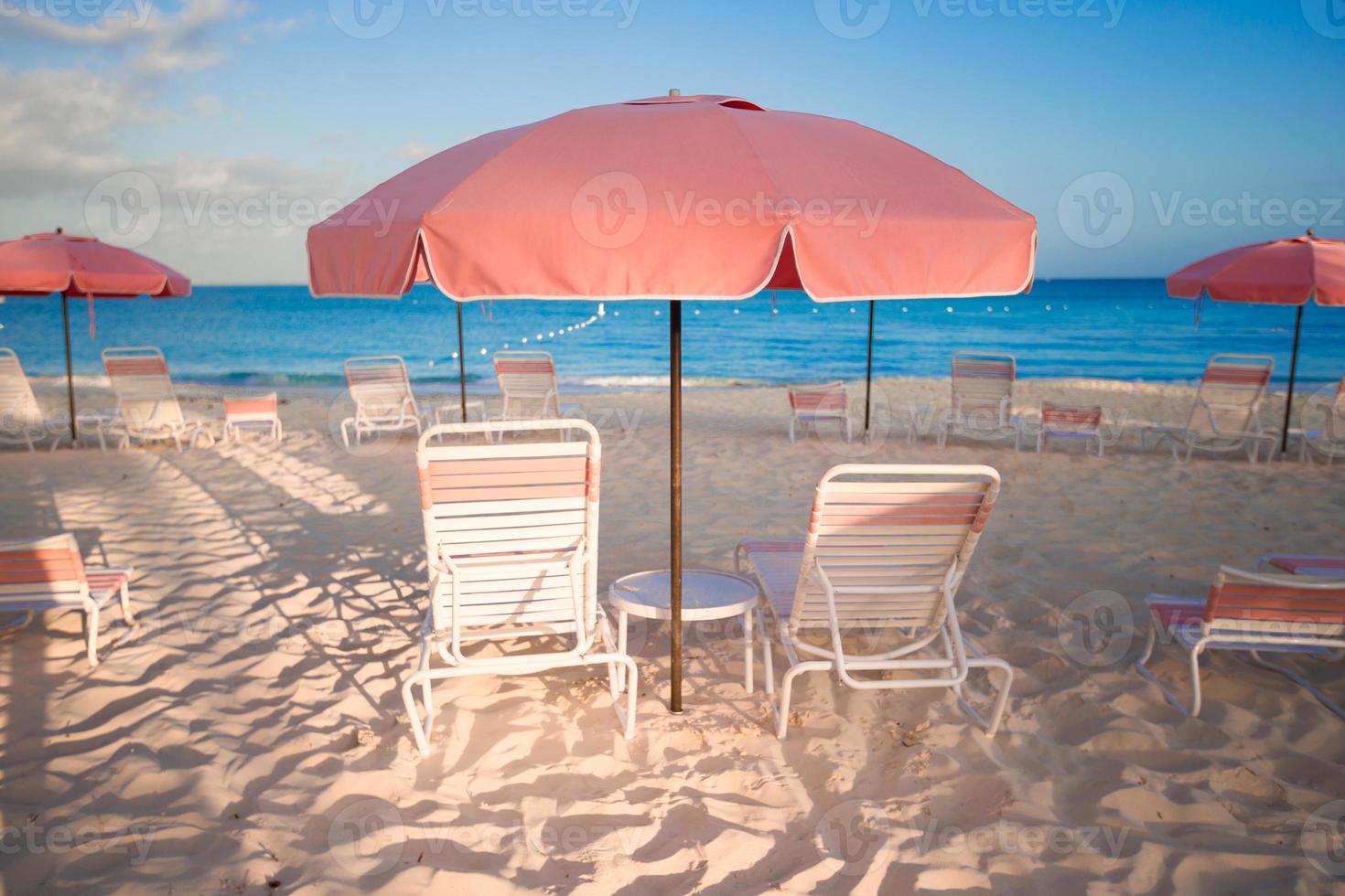 Tropical empty sandy beach with umbrella and chairs photo