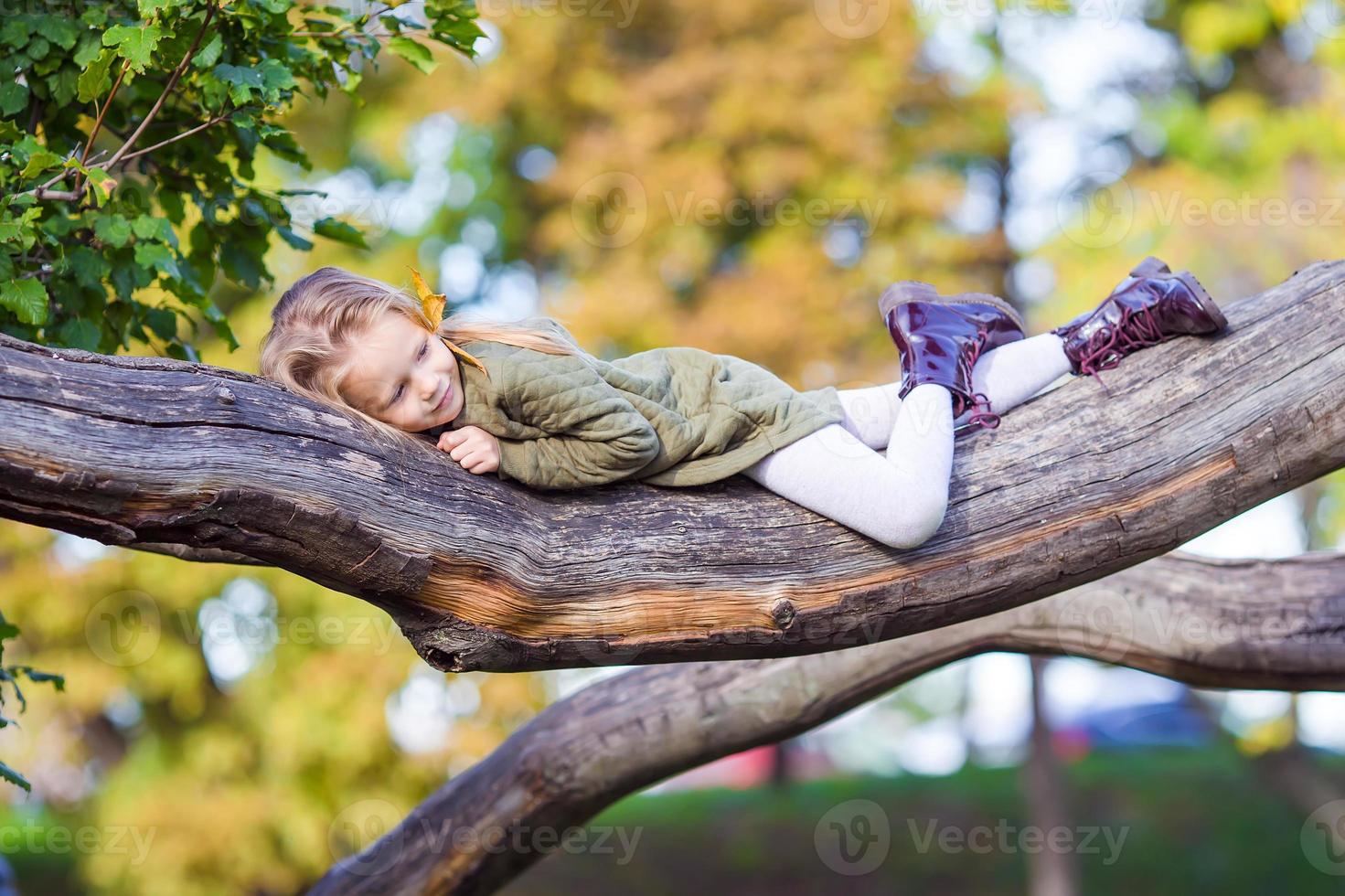 Happy little girl enjoy warm day in beautiful autumn park photo