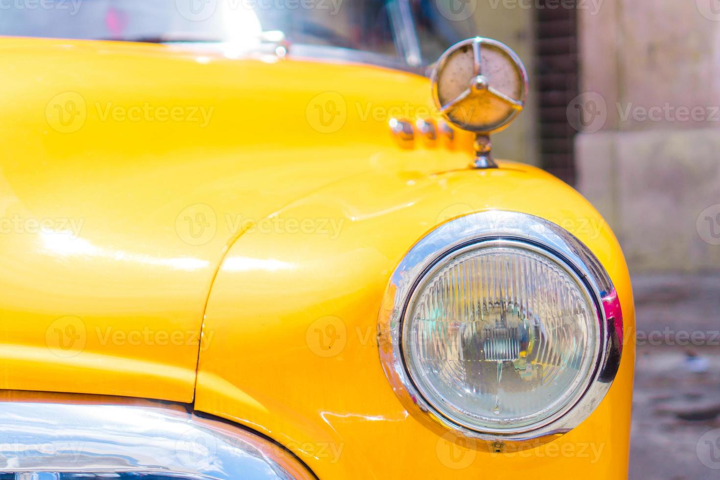 primer plano de un coche vintage clásico amarillo en la vieja habana, cuba foto