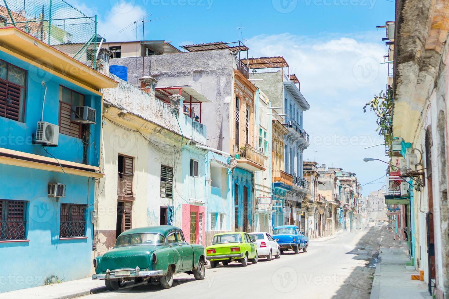 vista auténtica de una calle de la habana vieja con edificios y autos antiguos foto