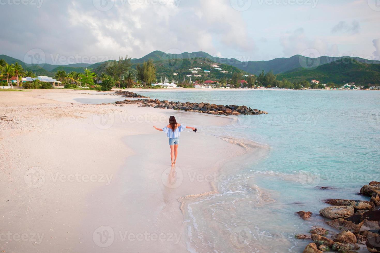 Young happy woman on white beach walking photo