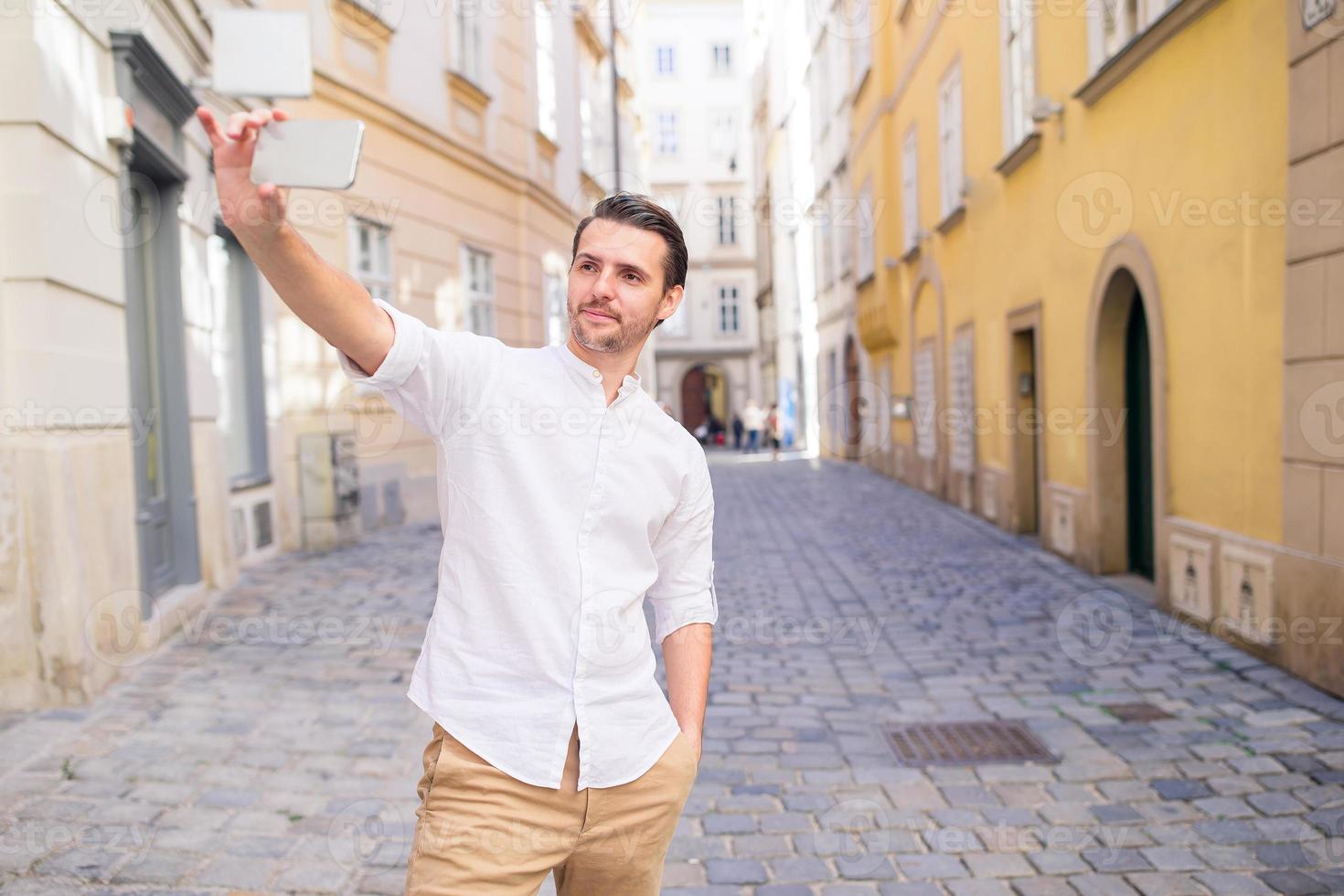 Man tourist with a city map and backpack in Europe street. Caucasian boy looking with map of European city. photo