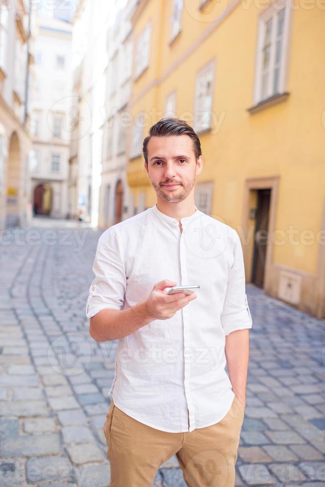 Man tourist with backpack in Europe street. Caucasian boy looking with map of European city. photo