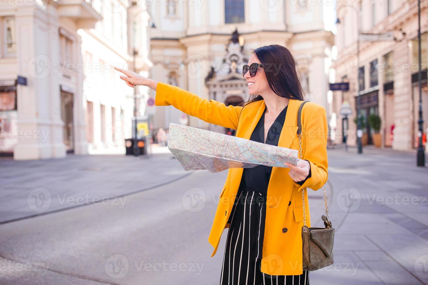 Young woman with a city map in city. Travel tourist girl with map in Vienna outdoors during holidays in Europe. photo