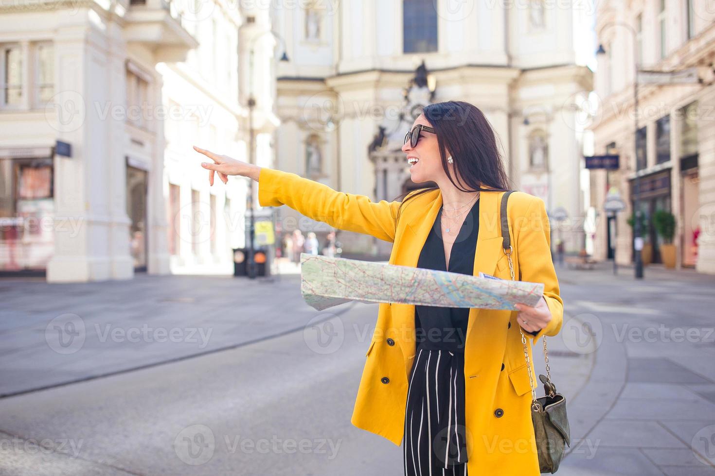 Young woman with city map in city. Travel tourist girl with map in Vienna outdoors during holidays in Europe. photo