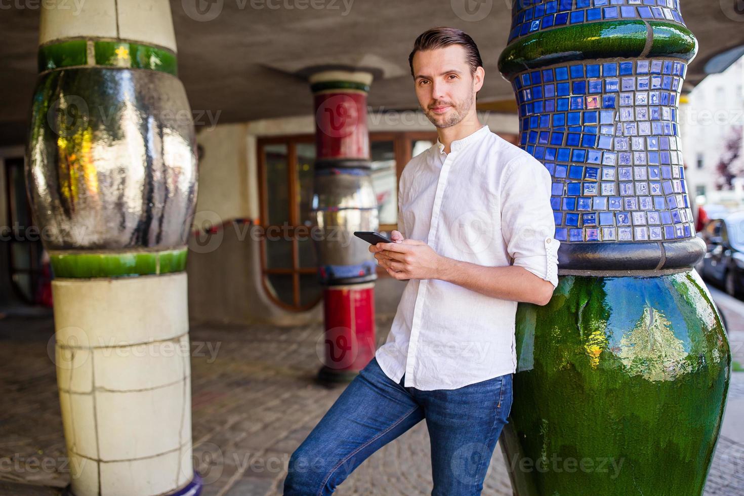 Man tourist with a city map and backpack in Europe street. Caucasian boy looking with map of European city. photo