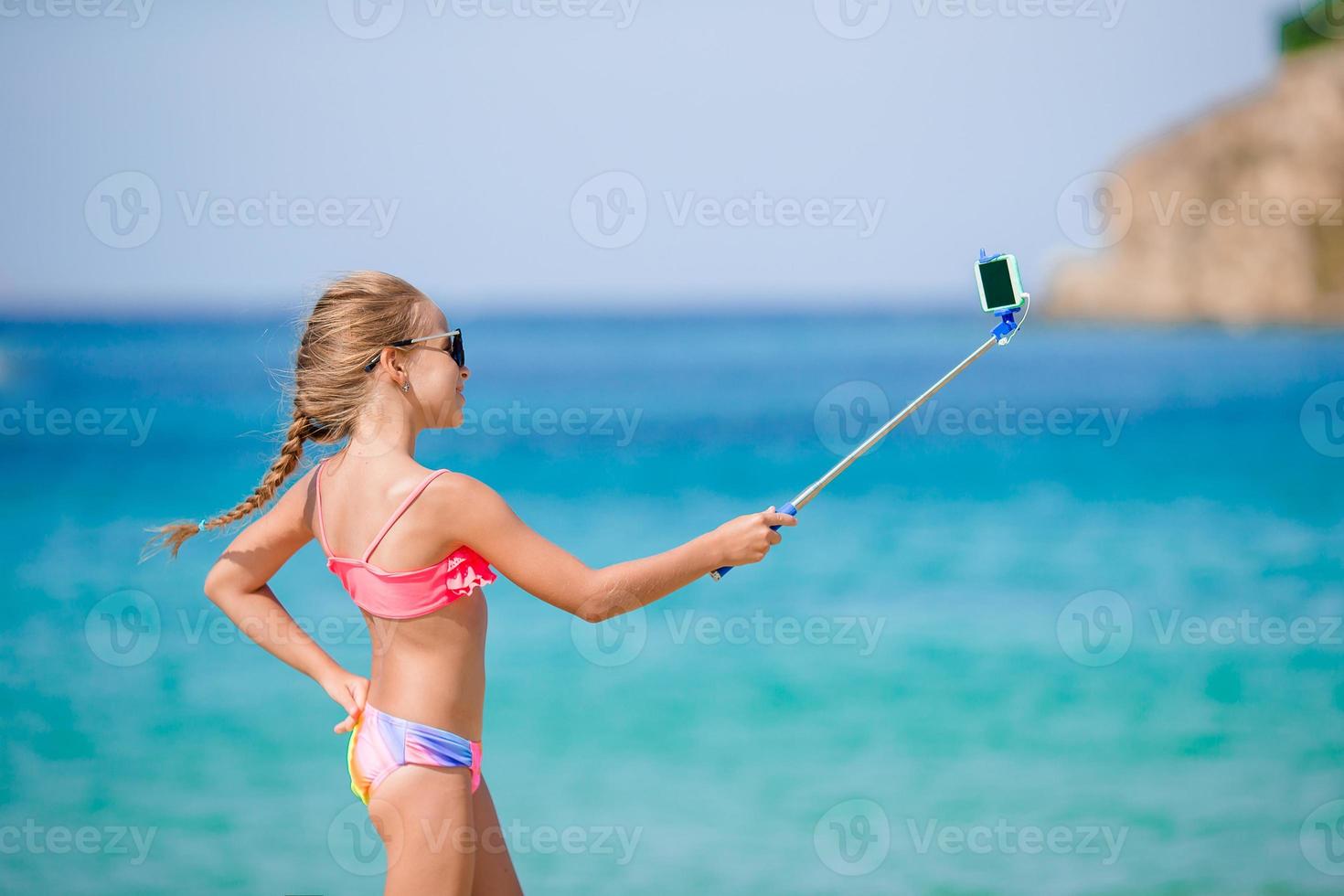 Little girl taking selfie portrait with her smartphone photo