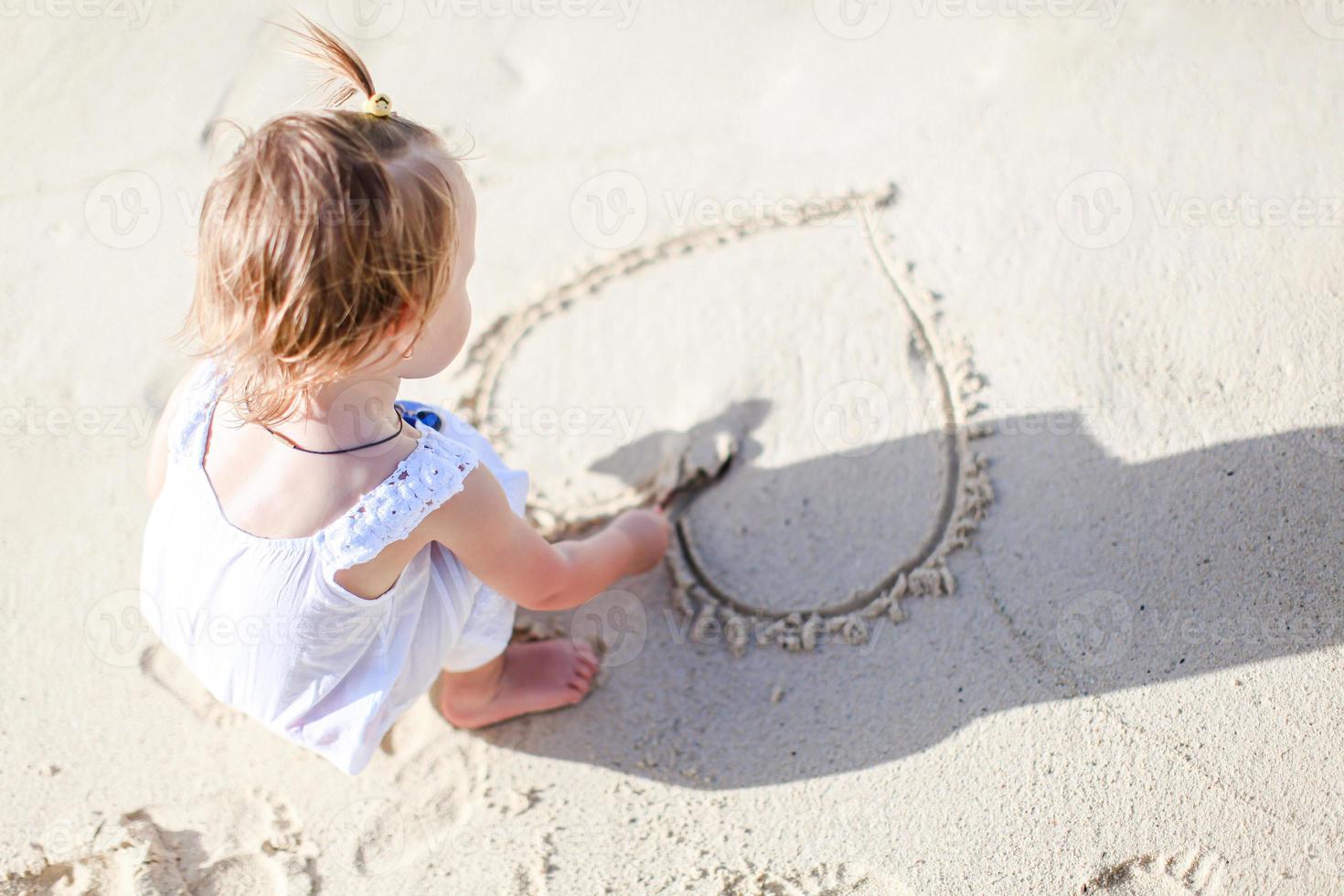 Adorable little girl have fun at tropical beach during vacation photo