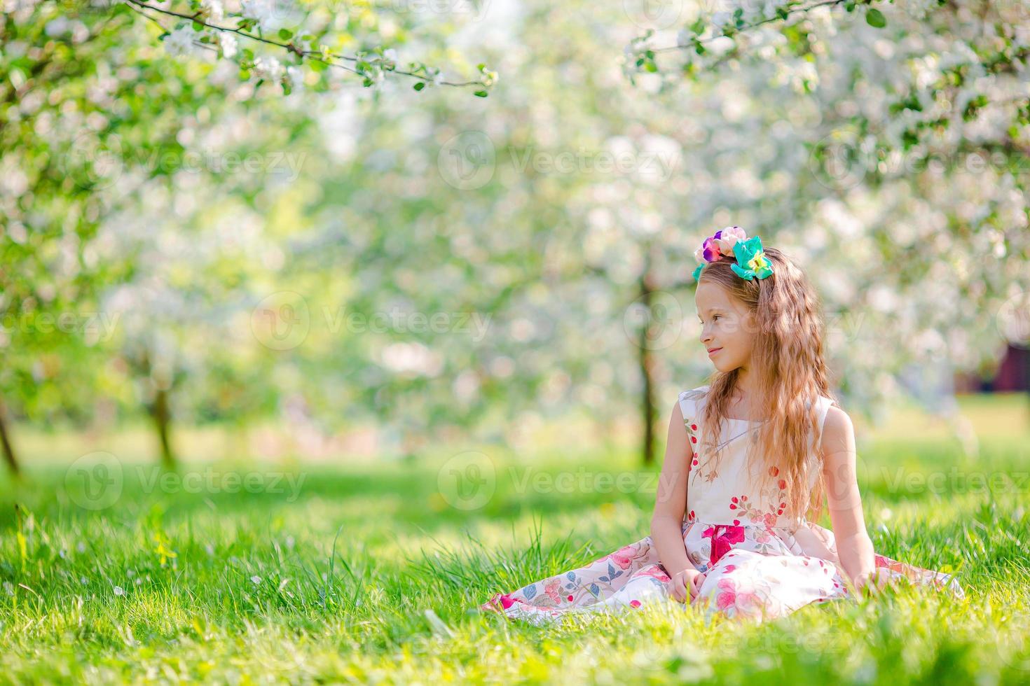 Adorable little girls in blooming apple tree garden on spring day photo