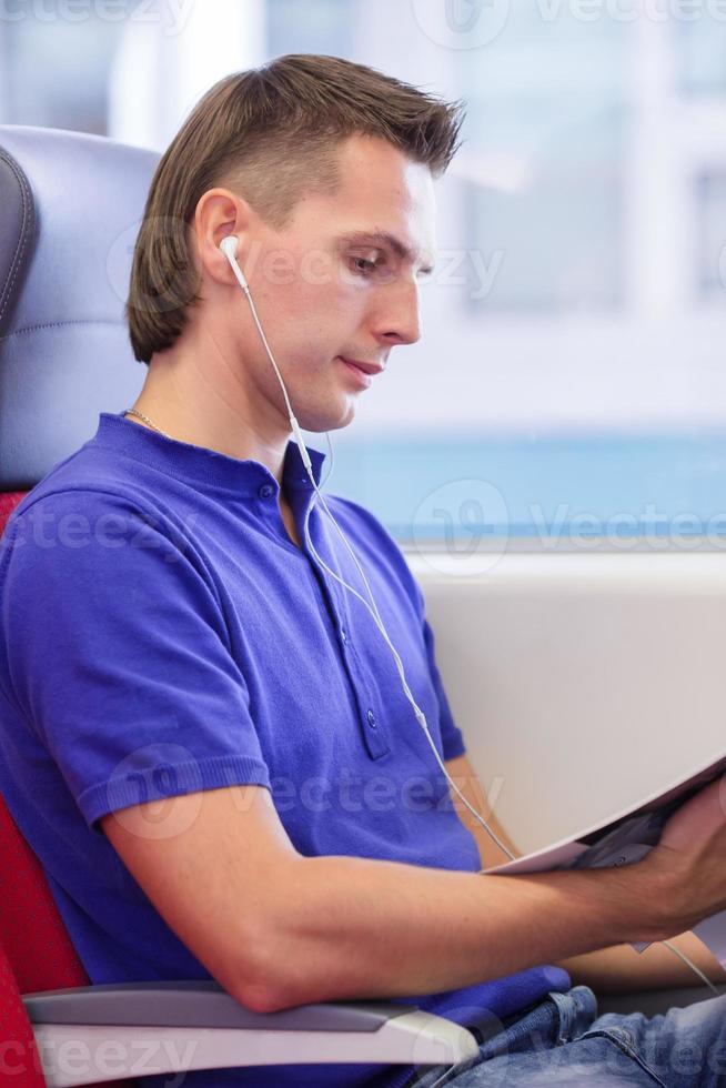 Happy caicasian tourist listening music traveling by train photo