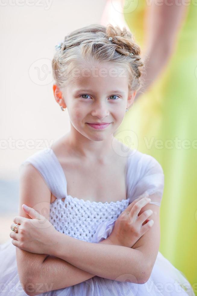 Adorable little girl in amazing dress at a wedding ceremony outdoors photo