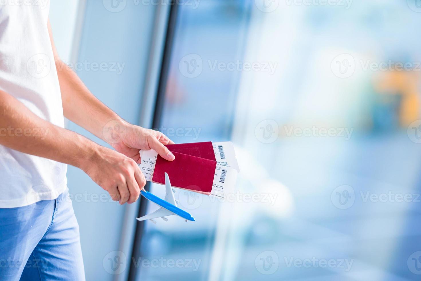 Closeup passports and boarding pass at airport in male hands photo