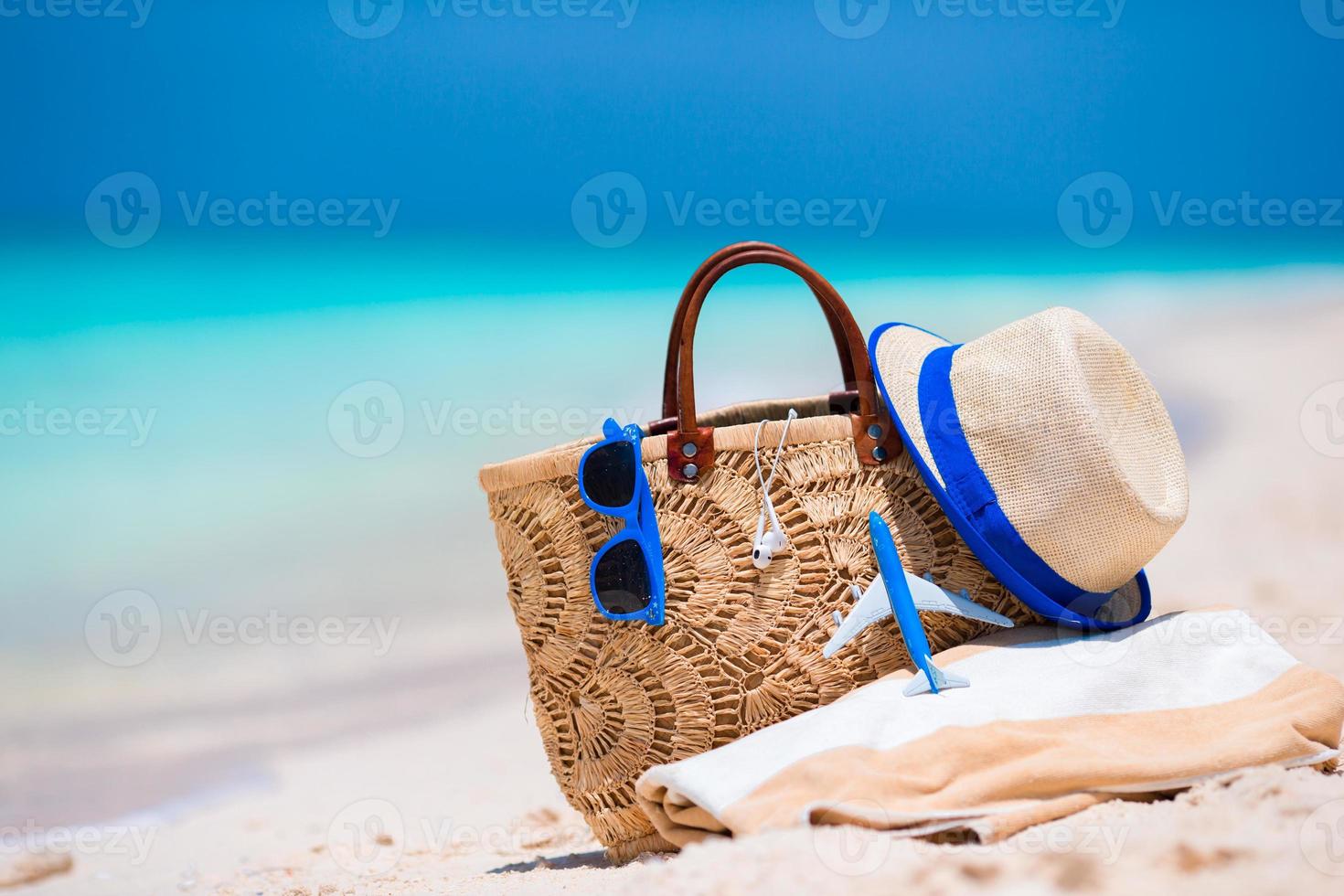 Beach consept - straw bag, hat, sunglasses and towel on white beach photo