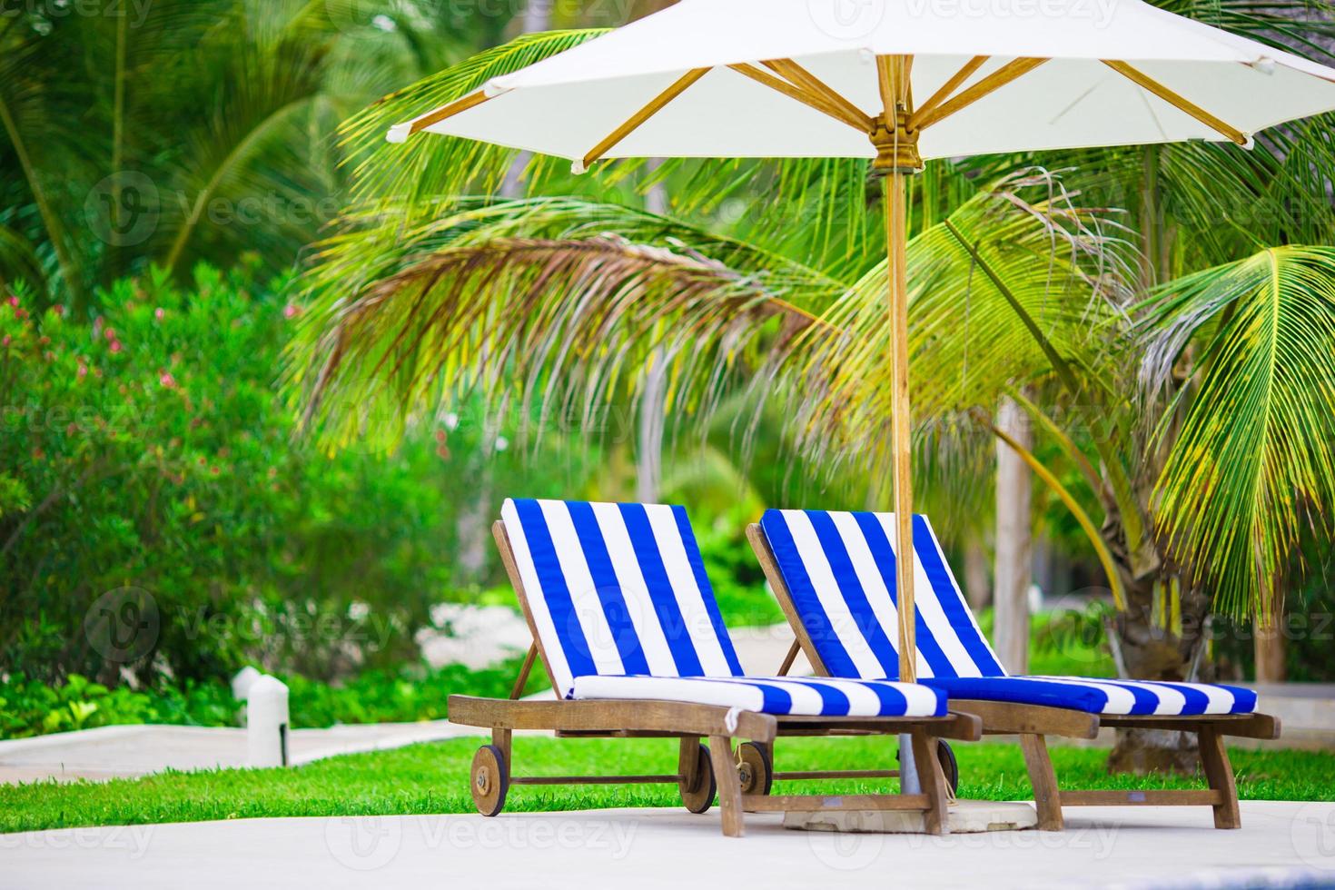 Beach chairs on exotic tropical white sandy beach photo