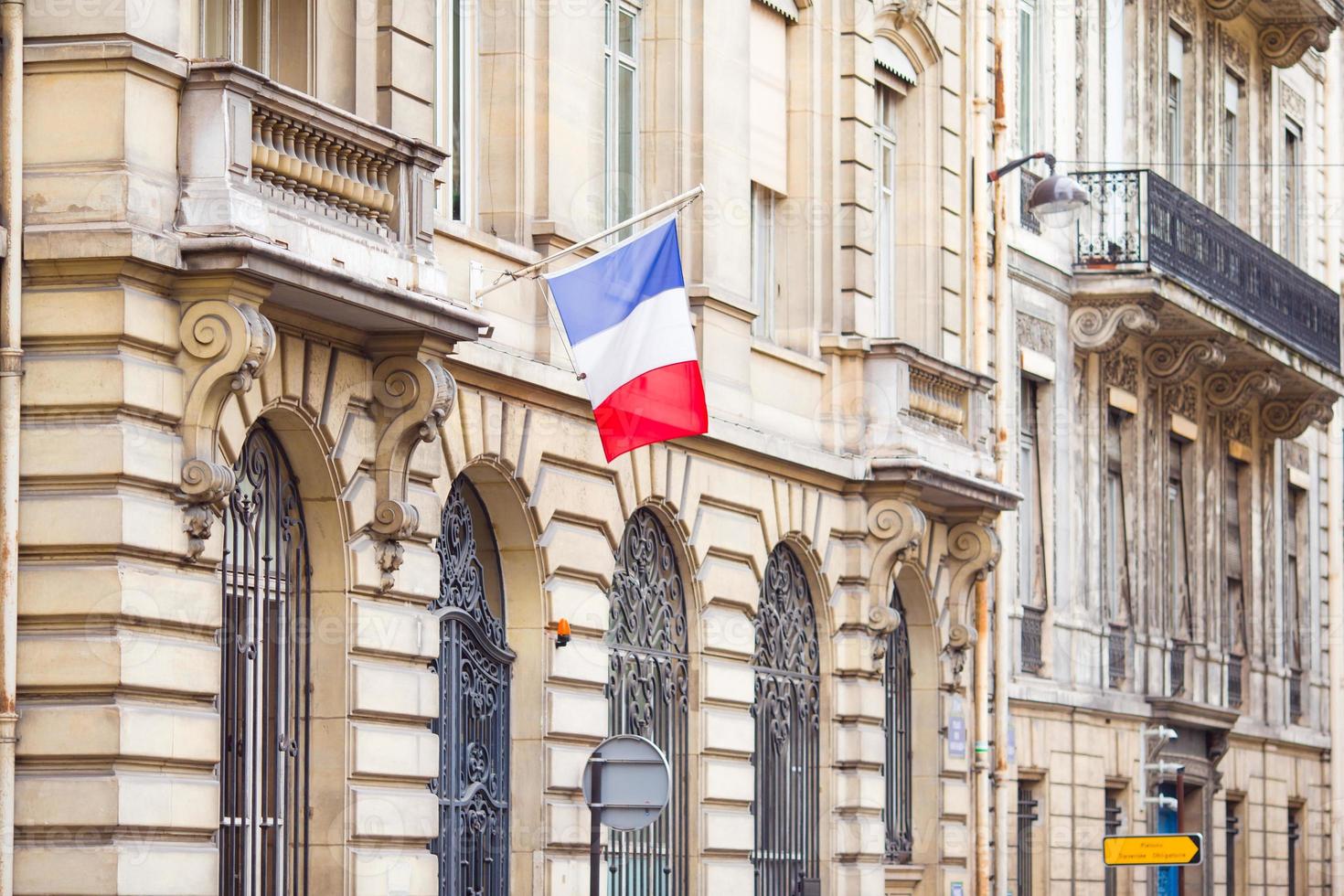 bandera francesa en la fachada del edificio histórico en París foto