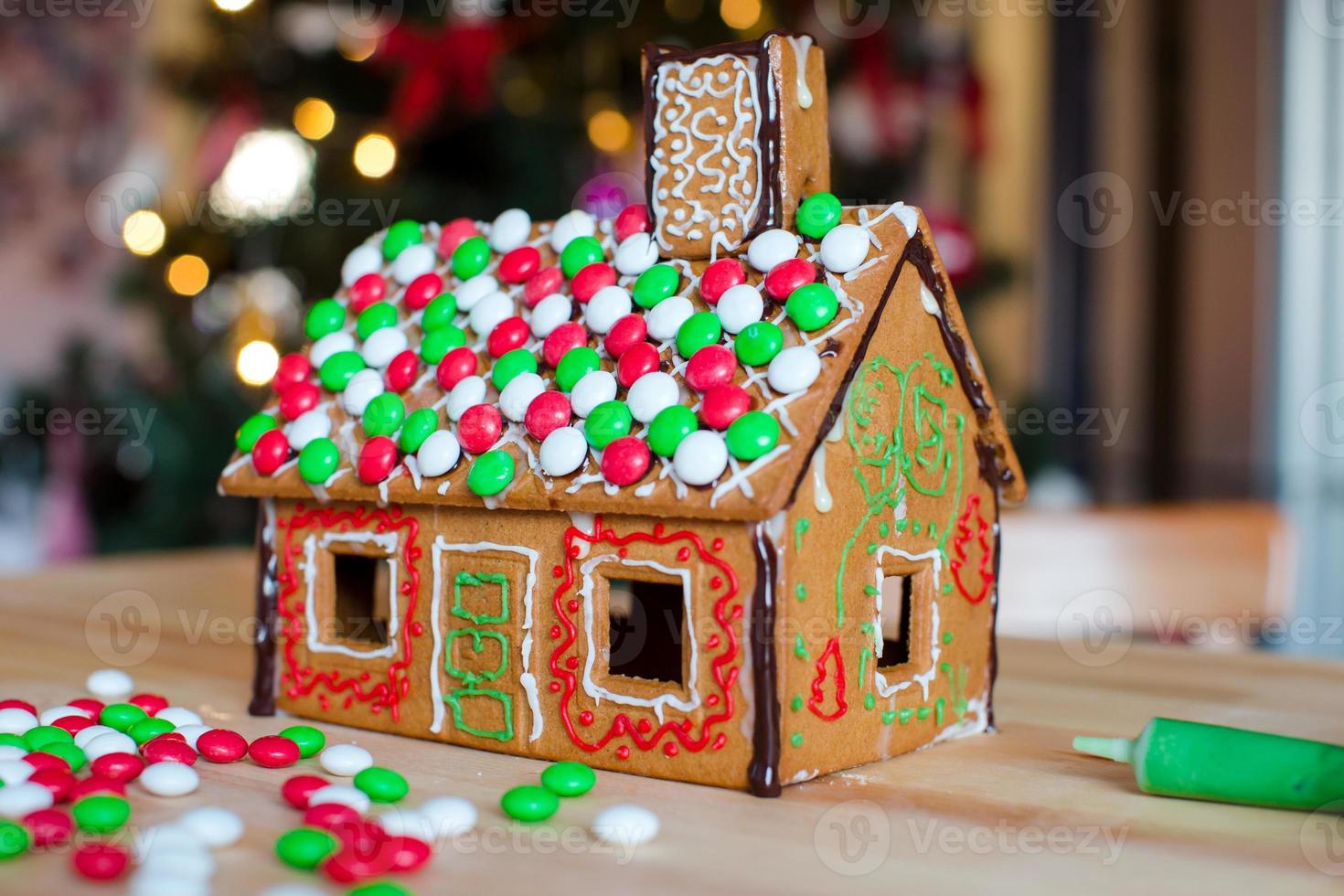 Gingerbread fairy house background of bright Christmas tree with garland photo