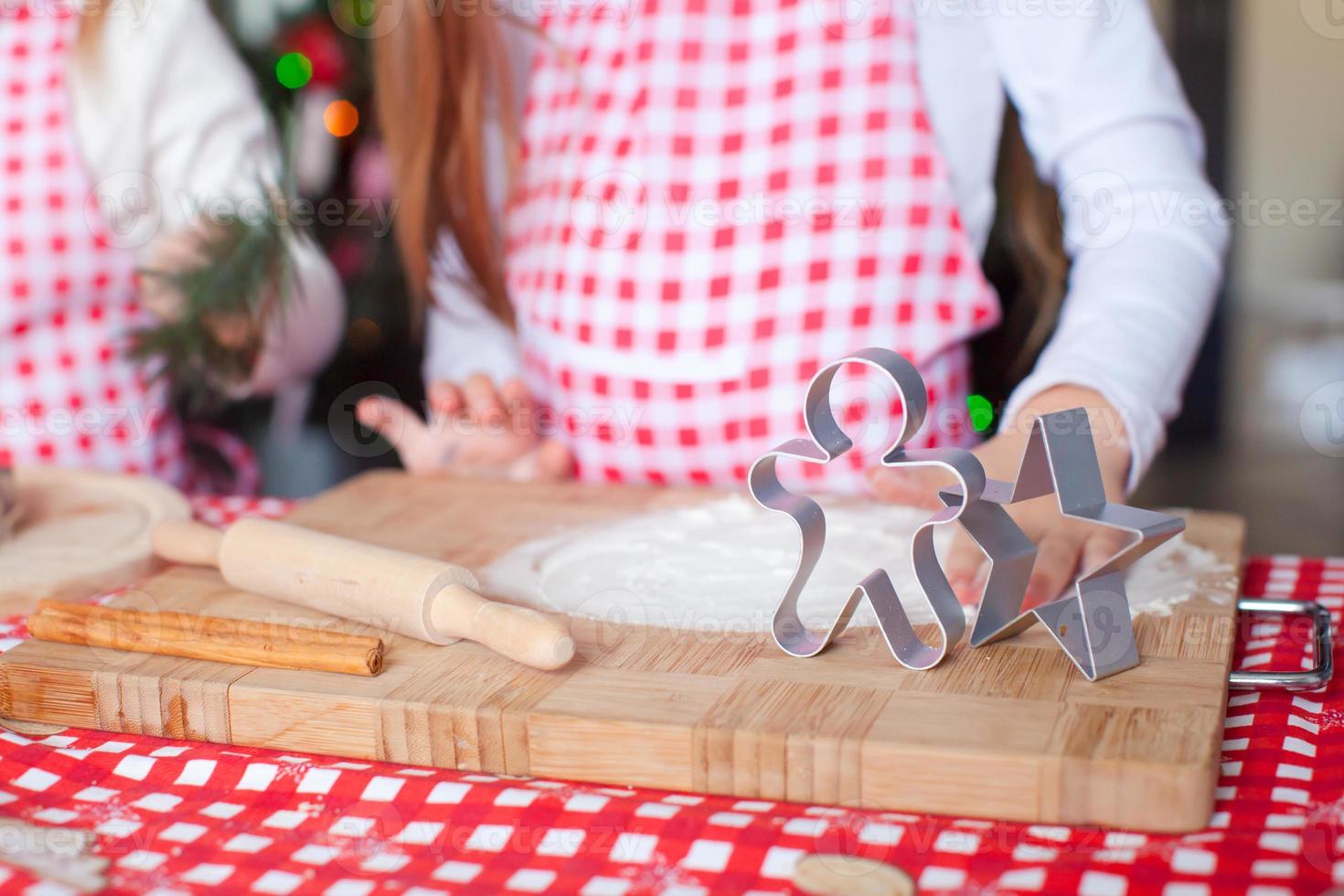 Little cute girl baking gingerbread cookies for Christmas at home kitchen photo