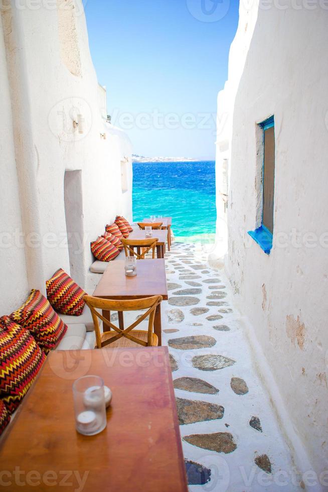 Benches with pillows in a typical greek bar in Mykonos with amazing sea view on Cyclades islands photo