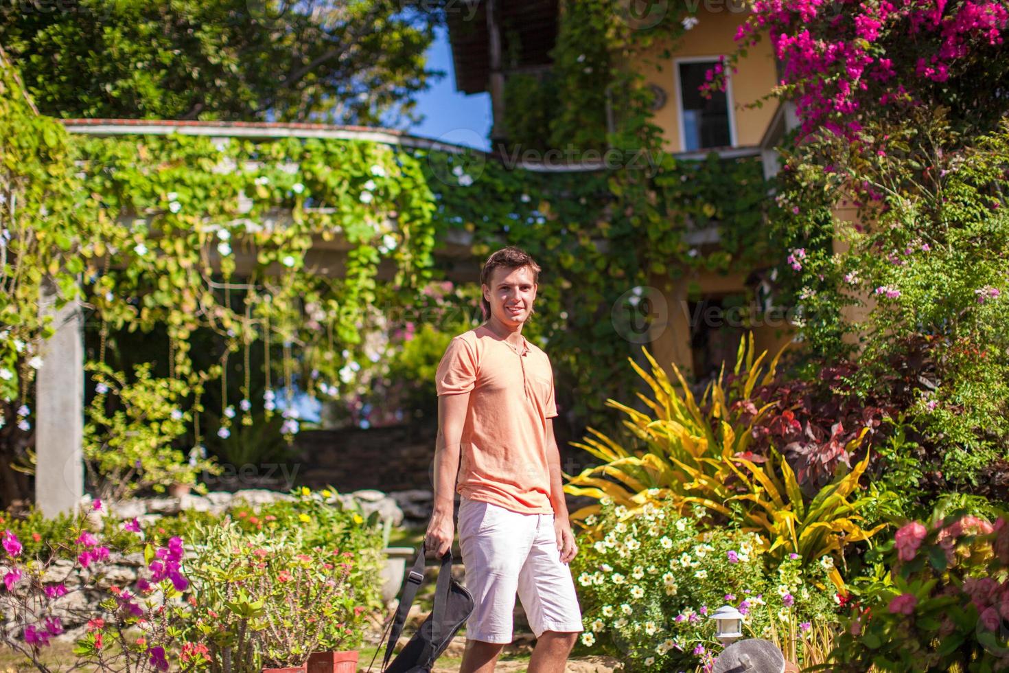 Young man in a flower garden at the exotic resort photo