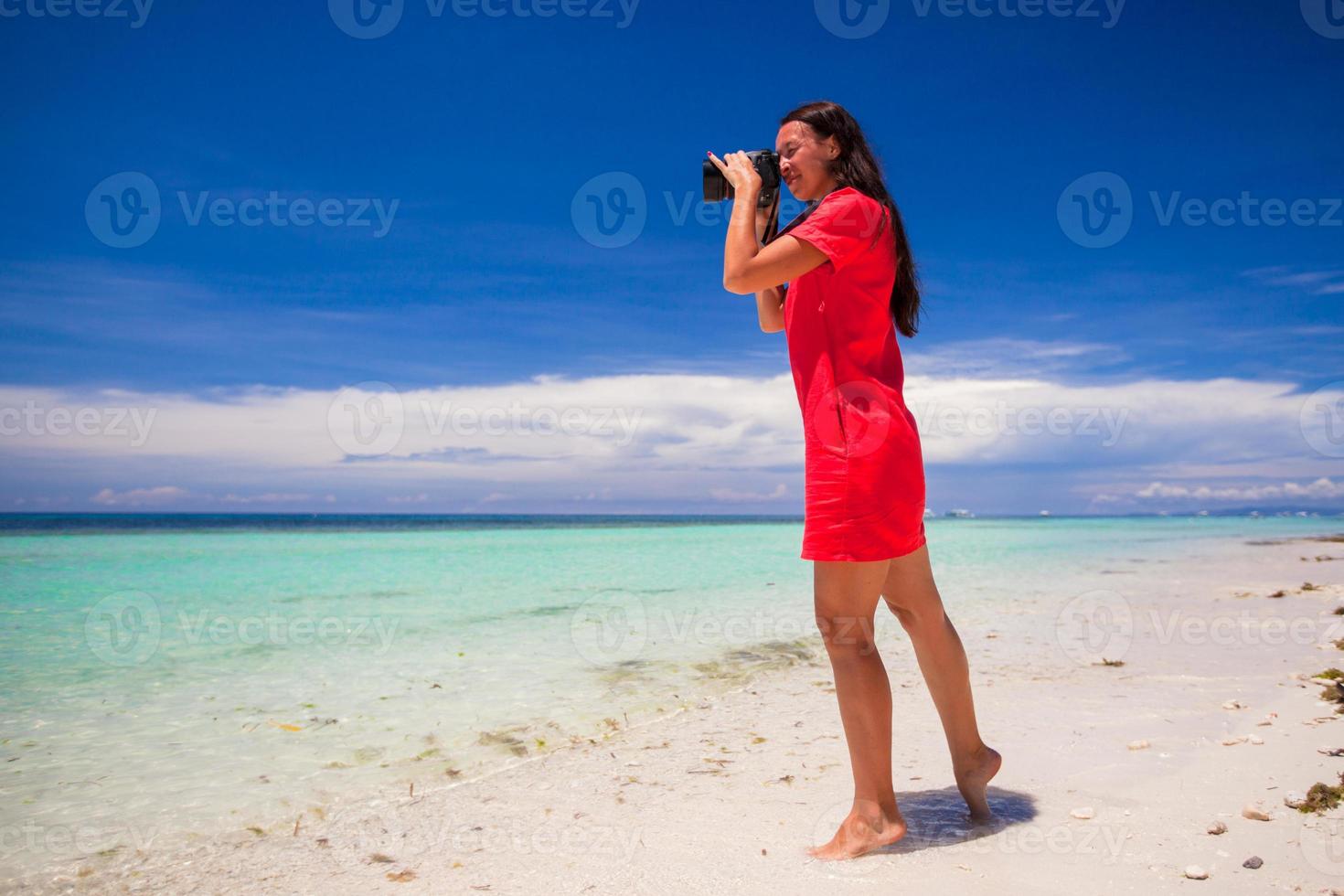 Young woman photographed beautiful sea on white sand beach photo