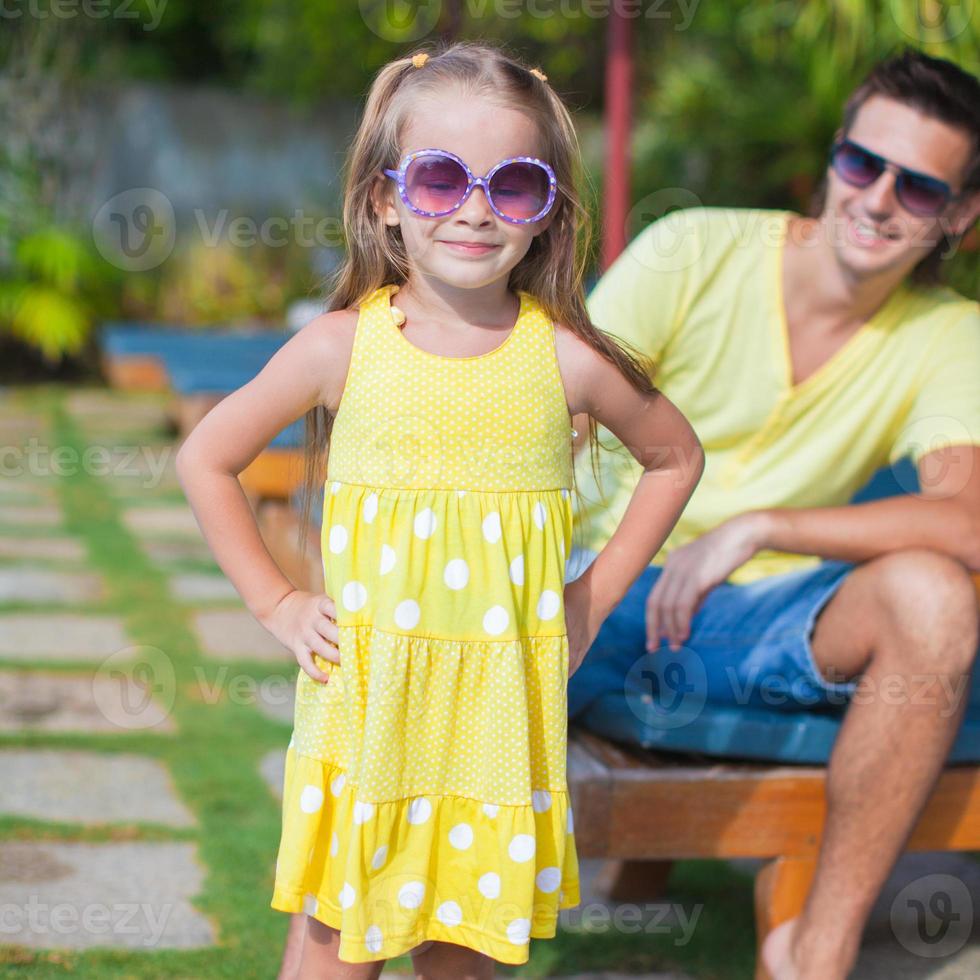 Close up little girl background her young dad at the swimming pool photo