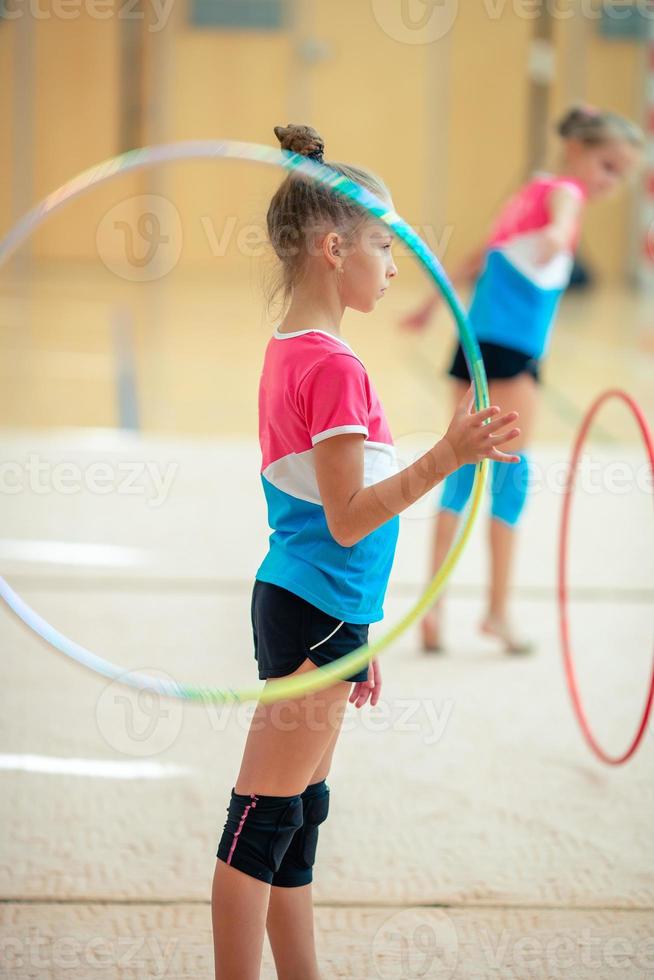 hermosa niña gimnasta activa con su actuación en la alfombra foto