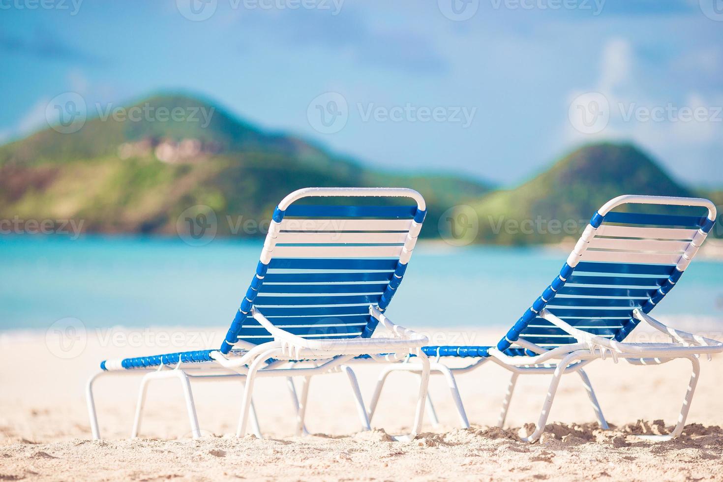 White lounge chairs on a beautiful tropical beach at Maldives photo