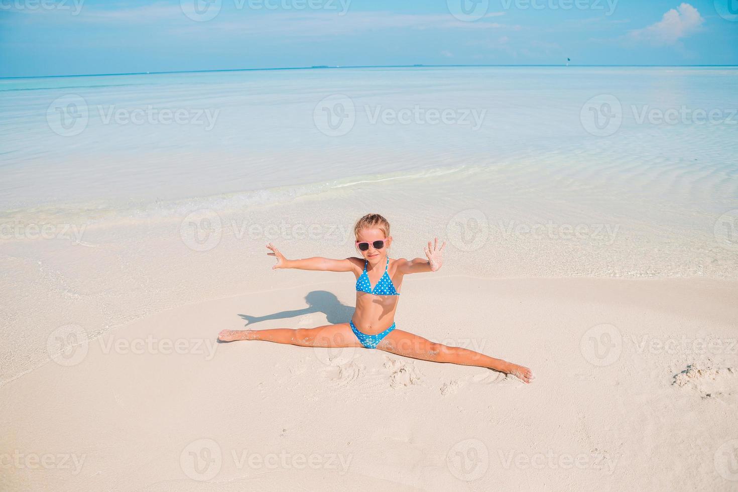 Little adorable girl playing on beach with ball photo