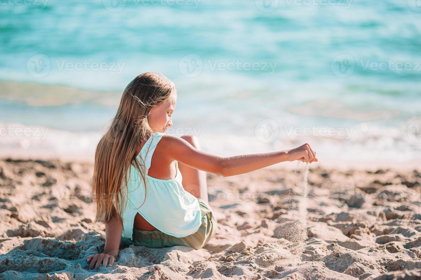 Adorable niña en la playa durante las vacaciones de verano foto