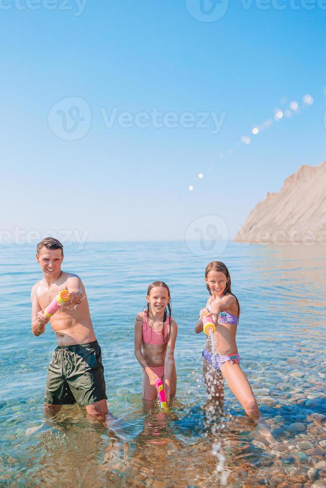Little girl and happy dad having fun during beach vacation photo