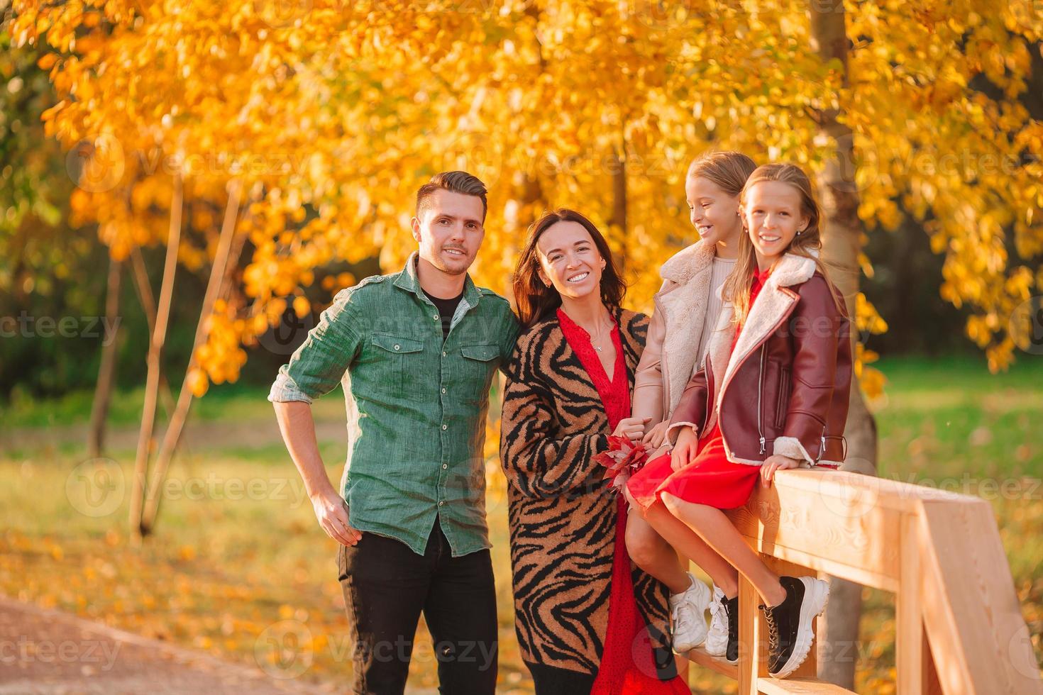 Portrait of happy family of four in autumn day photo