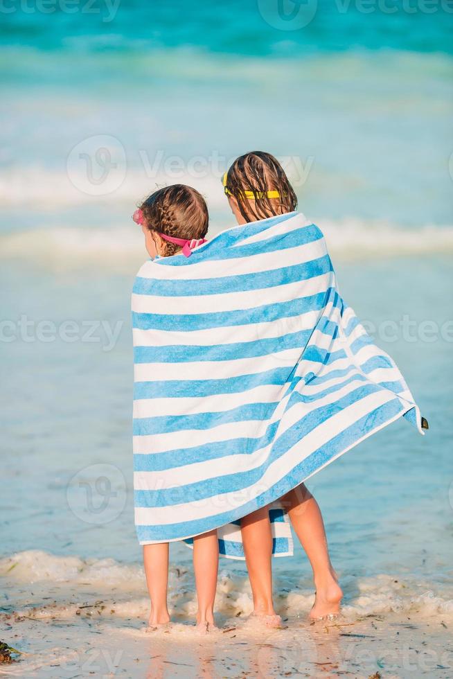 Adorable little girls wrapped in towel at tropical beach photo