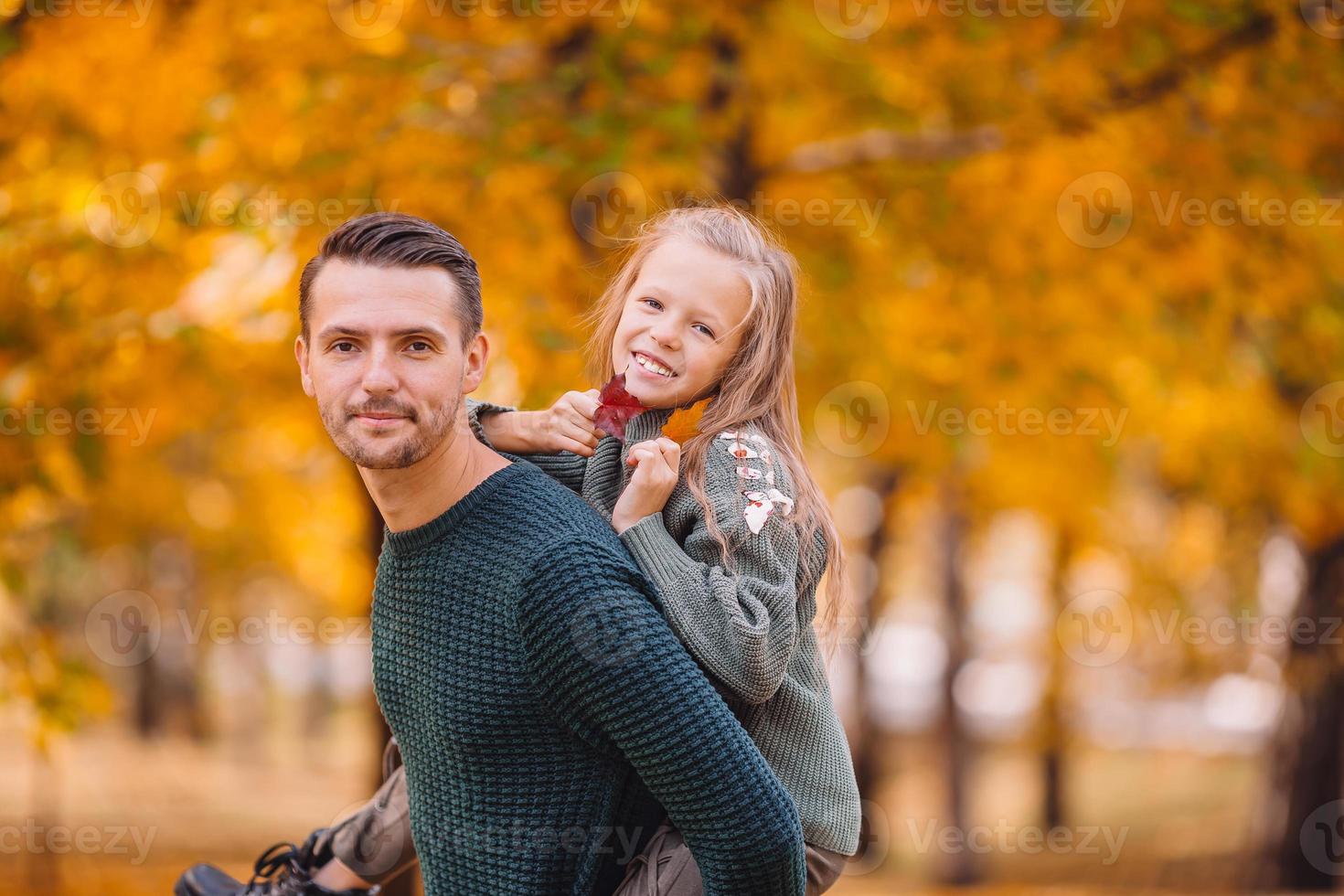 Family of dad and kid on beautiful autumn day in the park photo