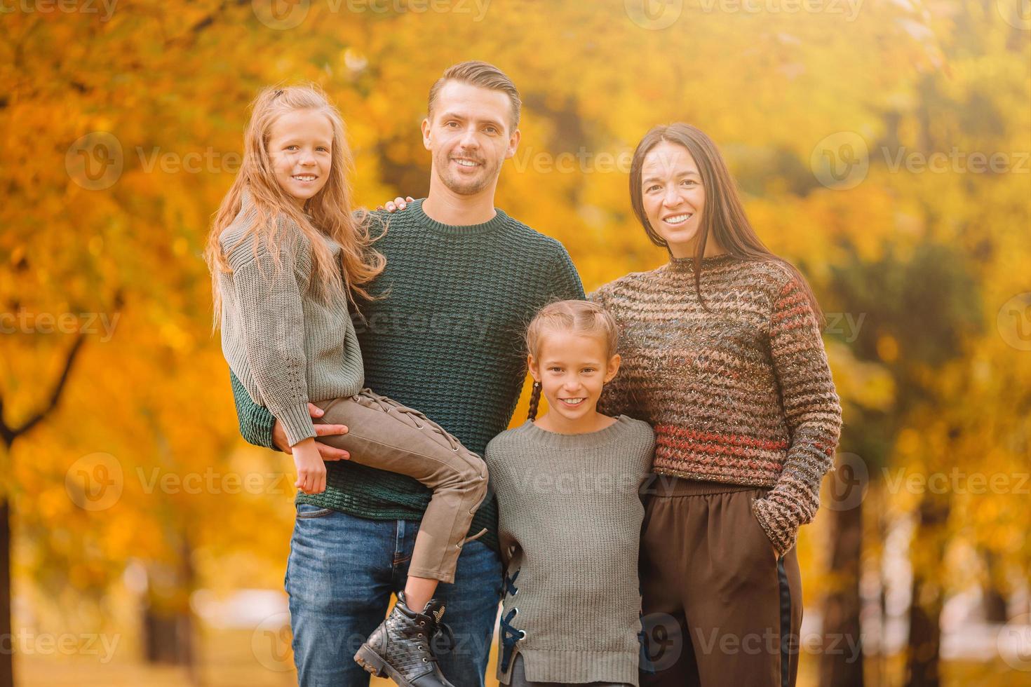 Portrait of happy family of four in autumn day photo